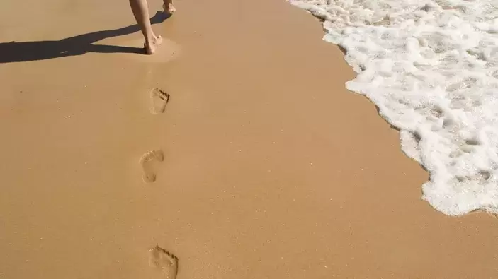 Fußabdrücke am sandigen Ufer